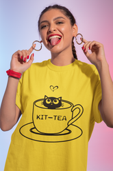 تي شيرت كلاسيك للجنسين برقبة مستديرة وعليه رسم "KIT-TEA" لقطة في فنجان شاي - تصميم مرح بكلمات متجانسة باللون الأسود